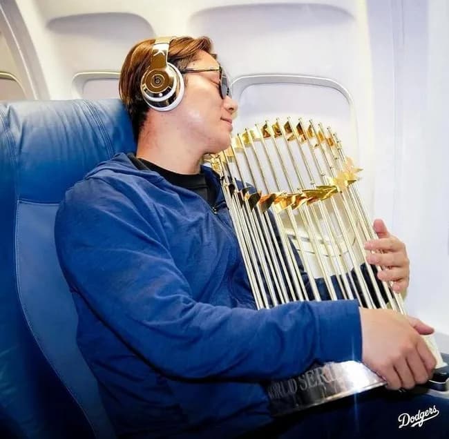 山本由伸さん、優勝トロフィーを抱いて機内でグッスリ眠る